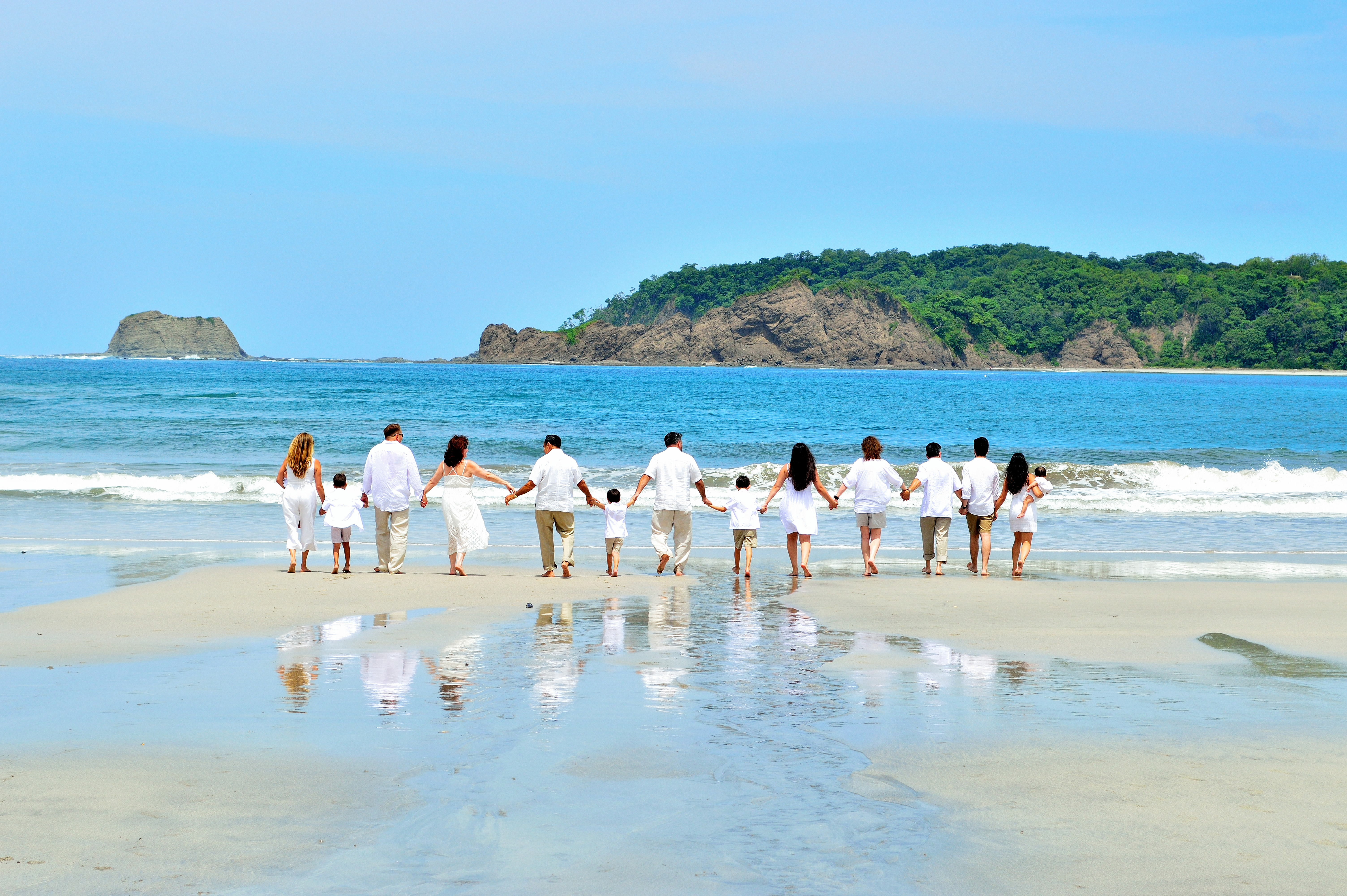 Costa Rican beach scene featuring a family enjoying palm trees and crystal clear water