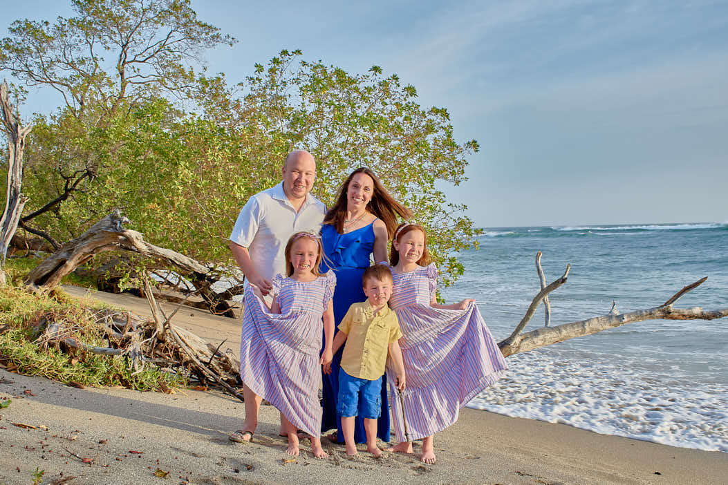 Costa Rican beach vacation with family and palm trees enjoying the crystal clear water
